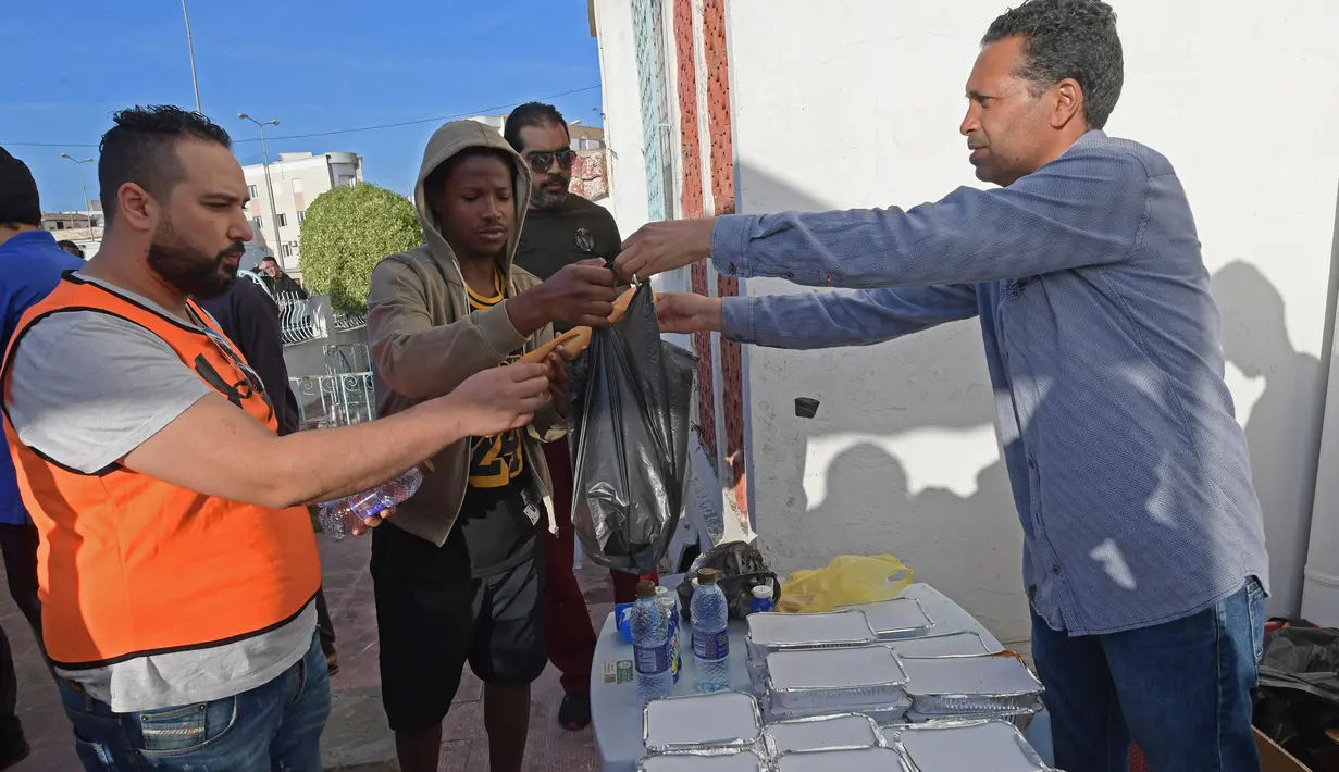 Relawan Tunisia membagikan makanan berbuka puasa gratis selama bulan suci Ramadan di Ariana dekat Tunis (7/5/2020). Masjid-masjid di Aljazair, Maroko dan Tunisia telah ditutup untuk membatasi penyebaran Covid-19, mencegah doa malam khusus. (AFP/Fethi Belad)