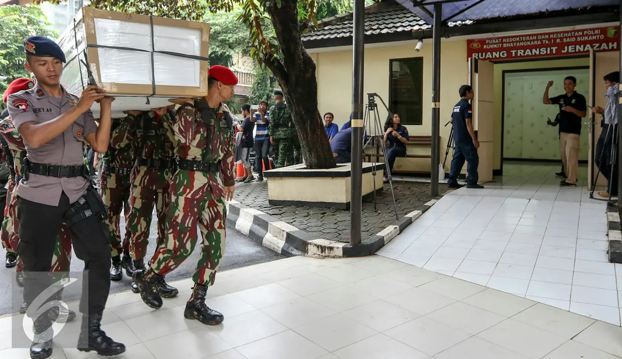 Petugas mengangkat 13 peti ke ruang transit jenazah yang dipersiapkan untuk korban helikopter TNI yang jatuh di RS Polri, Jakarta, Senin (21/3). Helikopter TNI AD jenis Bell 412 EP jatuh pada Minggu 20 Maret kemarin. (Liputan6.com/Yoppy Renato)
