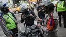 Petugas kepolisian lalu lintas mengecek STNK pengendara motor saat Operasi Zebra Jaya 2020 di kawasan Cawang, Jakarta, Senin (26/10/2020). Operasi Zebra Jaya dilaksanakan pada 26 Oktober-8 November 2020 untuk menekan jumlah pelanggaran lalu lintas. (Liputan6.com/Faizal Fanani)