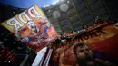 Suporter mengibarkan bendera bergambar gelandang AS Roma, Daniele De Rossi saat melawan Parma pada laga Serie A di Stadion Olympic, Roma, Minggu (26/5). Laga ini perpisahan bagi De Rossi dan AS Roma setelah 18 tahun. (AFP/Filippo Monteforte)