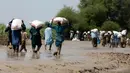 Korban banjir saat menerima bantuan Yayasan Edhi di Distrik Ghotki, Sindh Pakistan, Rabu (7/9/2022). Sekarang ada risiko tinggi penyakit yang ditularkan melalui air, penyakit mematikan yang menyebar dengan cepat, diare, kolera, demam berdarah, malaria. (AP Photo/Fareed Khan)