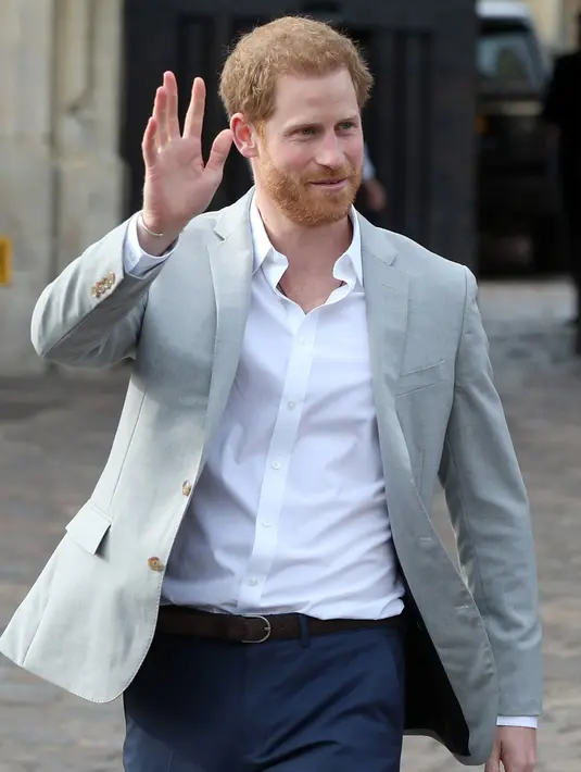Pangeran Harry melambaikan tangan kepada orang-orang di luar Kastil Windsor, Inggris, Jumat (18/5). Pangeran Harry dan Meghan Markle akan menikah pada 19 Mei 2018. (Jonathan Brady/POOL/AFP)