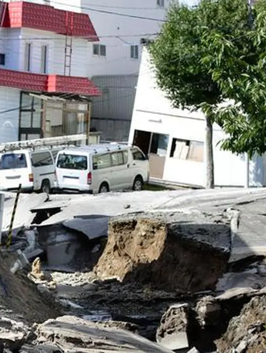 Sejumlah warga melihat kondisi jalan yang mengalami kerusakan parah akibat Gempa magnitudo 6,7 di Sapporo, Hokkaido, Jepang, Kamis (6/9). (Hiroki Yamauchi/Kyodo News via AP)