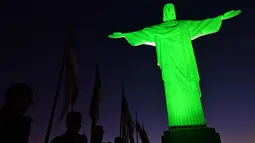 Tentara dalam upacara adat berbaris di depan patung Kristus Penebus setelah dinyalakan hijau untuk menandai hari Tentara Nasional, di Rio de Janeiro, Brasil (19/4). (AFP Photo/Carl De Souza)