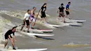 Sejumlah warga saat menikmati bermain surfing di Sungai Dordogne, Saint-Pardon, Prancis (24/7). Fenomena pasang surut besar ini terjadi beberapa kali dalam setahun. (AFP Photo/Georges Gobet)