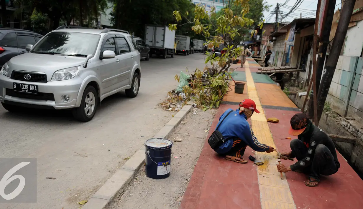 Pekerja menyelesaikan pembangunan Trotoar Ramah Disabilitas di Jalan Hidup Baru, Kalimati, Jakarta Utara, Selasa (27/12). Nantinya trotoar ini akan dibangun sepanjang 753 meter dan lebar 2,4 meter. (Liputan6.com/Gempur M. Surya)