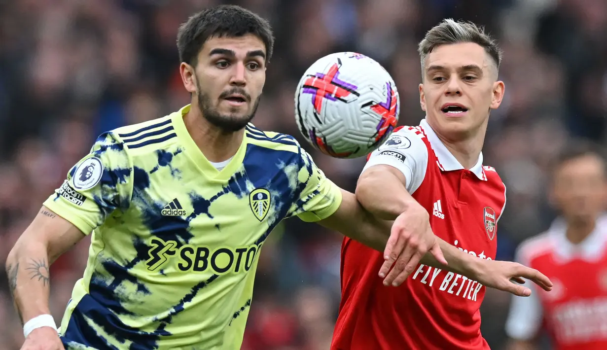 Pemain Arsenal, Leandro Trossard (kanan) berebut bola dengan pemain Leeds United, Pascal Struijk pada laga pekan ke-29 Liga Inggris 2022/2023 di Emirates Stadium, London, Minggu (02/04/2023) dini hari WIB. The Gunners menang dengan skor 4-1. (AFP/Glyn Kirk)