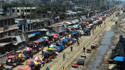 Warga memadati jalan yang dipenuhi lapak pedagang di area pasar tradisional selama karantina wilayah masih diberlakukan pemerintah setempat di Dhaka, Bangladesh (12/5/2020). (AFP/Munir Uz Zaman)
