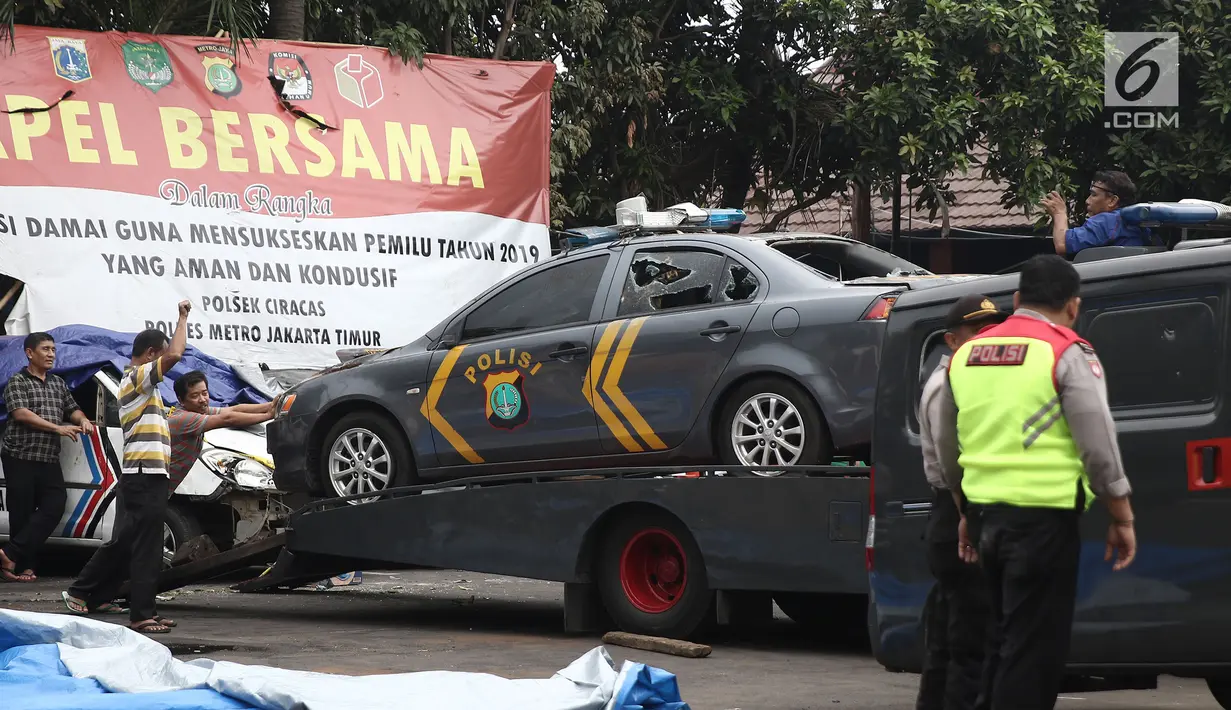 Petugas Ditlantas Polda Metro Jaya membawa mobil dinas polisi di Mapolsek Ciracas, Jakarta, Rabu (12/12). Aksi penyerangan terhadap Polsek Ciracas diduga akibat ketidakpuasan terhadap penanganan. (Liputan6.com/Herman Zakharia)