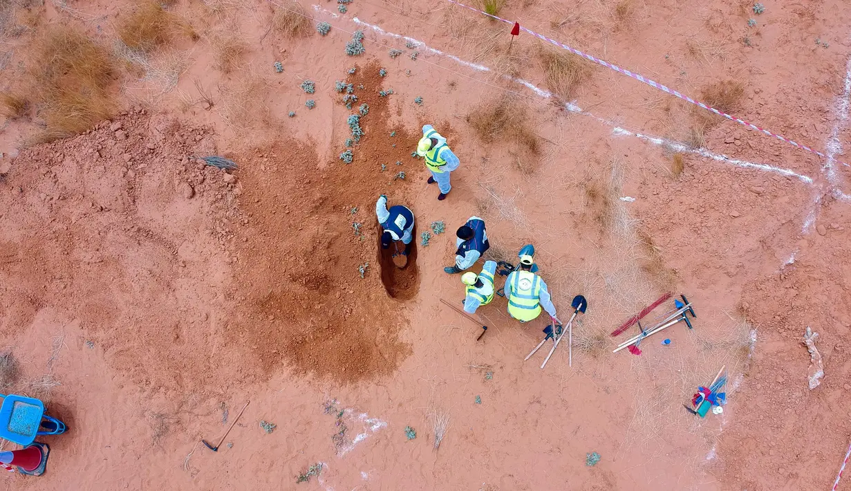 Foto dari udara memperlihatkan tim pakar bekerja di lokasi kuburan massal di Kota Tarhuna, Libya, Selasa (23/6/2020). Direktur Departemen Pencarian Jasad Lutfi Al-Misurati mengatakan 10 jasad tak dikenal ditemukan di kuburan massal Kota Tarhuna. (Xinhua/Hamza Turkia)