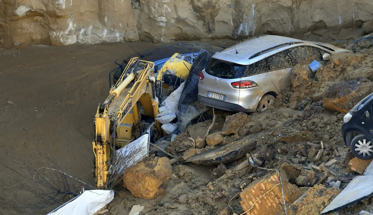 Alat berat dan mobil terlihat ikut ambles ke dalam lubang besar yang menganga di distrik Balduina, Roma, Kamis (15/2). Tidak ada korban jiwa dalam insiden yang terjadi di kawasan permukiman mewah di Roma barat laut itu. (AFP PHOTO / TIZIANA FABI)