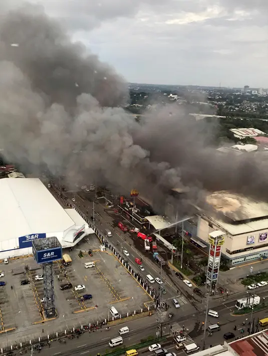 Kepulan asap membubung tinggi saat terjadi kebarakan di mal di kota Davao, Filipina Selatan (23/12). Api pertama kali membara di sebuah toko yang berada di lantai tiga Mal NCCC pada Sabtu 23 Desember pagi waktu setempat. (AP Photo / Manman Dejeto)