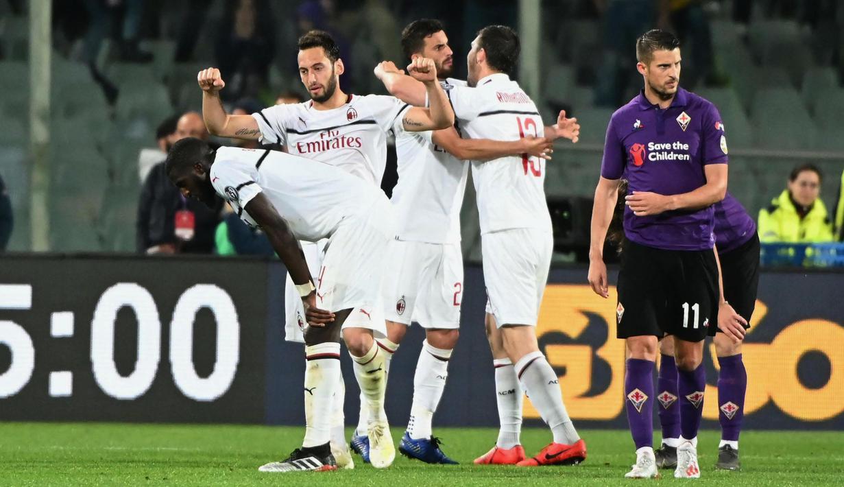 Gelandang AC Milan, Hakan Calhanoglu, melakukan selebrasi usai membobol gawang Fiorentina pada laga Serie A di Stadion Artemio Franchi, Sabtu (11/5). AC Milan menang 1-0 atas Fiorentina. (AP/Claudio Giovanni)