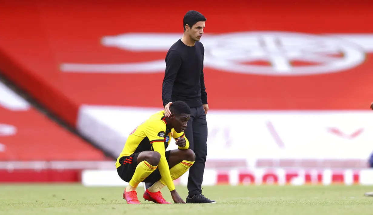 Pelatih Arsenal, Mikel Arteta, berusaha menenangkan pemain Watford,Christian Kabasele, pada laga Premier League di Stadion Emirates, Minggu (26/7/2020). Arsenal menang 3-2 atas Watford. (AP photo/ Rui Vieira, Pool)