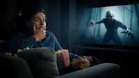 Pria sedang menonton film horor. [Foto: Gemini]