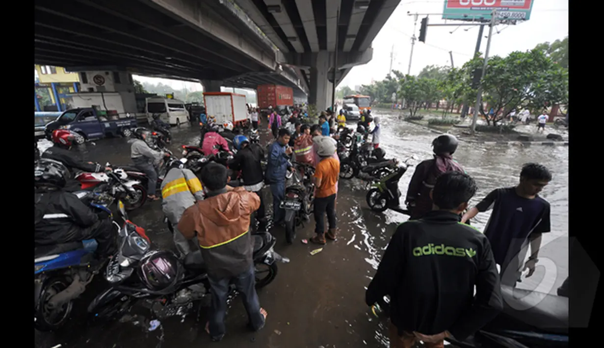 Sejumlah Pengendara Motor saat berada dibawah jembatan untuk memperbaiki motor yang mati akibat banjir, Jakarta, Senin (6/2/2015).  Hujan yang turun sejak malam hingga kini membuat sejumlah ruas jalan tergenang air. (Liputan6.com/Faizal Fanani)