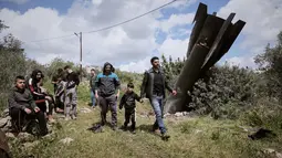 Puing rudal Iran ditemukan di desa Kifl Haris, dekat Nablus, Tepi Barat pada Selasa 24 Maret 2026. Tampak dalam foto, warga Palestina mengamati puing-puing rudal Iran yang jatuh di desa Kifl Haris, Tepi Barat, Selasa, 24 Maret 2026. (AP Photo/Majdi Mohammed)