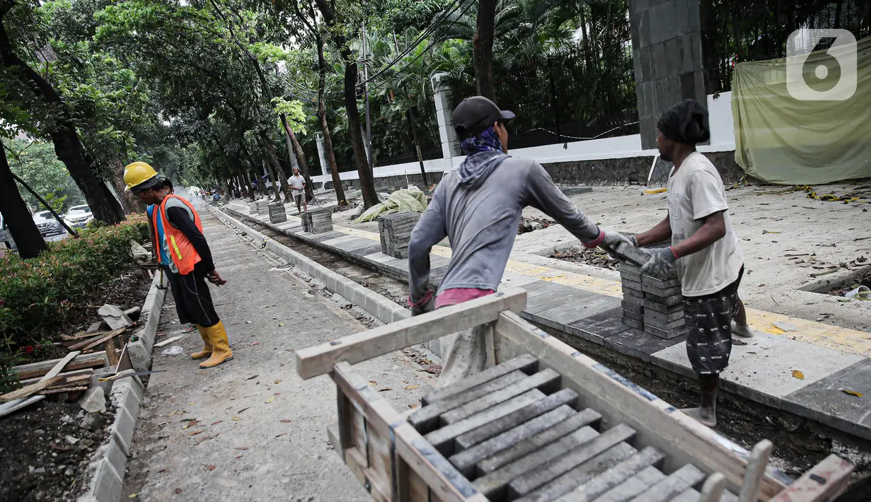 Pekerja menyelesaikan proyek revitalisasi pedestrian di kawasan Jalan Pattimura, Jakarta, Rabu (8/6/2022). Dinas Bina Marga DKI Jakarta merevitalisasi pedestrian dengan memperlebar menjadi tiga meter sehingga cukup luas untuk memberikan kenyamanan para pejalan kaki. (Liputan6.com/Faizal Fanani)