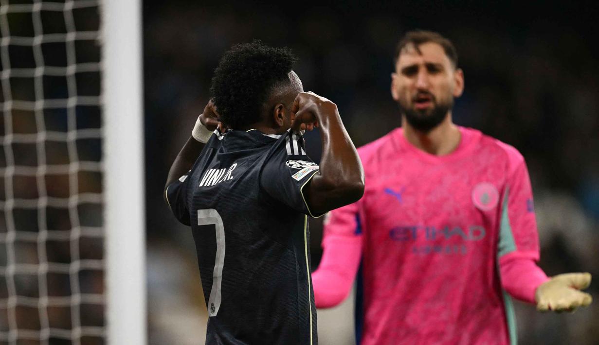 Bertanding di Etihad Stadium pada Selasa 17 Maret 2026 waktu setempat atau Rabu (18/3) dini hari WIB, Los Blancos sukses mempermalukan tuan rumah 2-1. Tampak dalam foto, ekspresi kiper Manchester City asal Italia, Gianluigi Donnarumma (kanan), saat penyerang Real Madrid asal Brasil, Vinicius Junior, merayakan gol yang kemudian dianulir karena offside saat pertandingan leg kedua 16 besar Liga Champions 2025/2026 di Etihad Stadium, barat laut Inggris, pada Selasa 17 Maret 2026 waktu setempat atau Rabu (18/3) dini hari WIB. (Oli SCARFF/AFP)