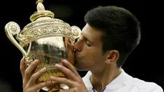 Petenis Serbia, Novak Djokovic mencium trofi kemenangannya setelah mengalahkan petenis Swiss, Roger Federer di babak final tunggal putra Wimbledon 2015, London, Minggu (12/7). Ini adalah gelar Wimbledon ketiga bagi Djokovic.  (REUTERS/Stefan Wermuth)