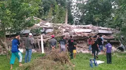 Warga berkumpul di sekitar bangunan roboh menyusul gempa 6,4 SR yang mengguncang Kabupaten Pidie Jaya, Aceh, Rabu (7/12). Empat orang dikabarkan meninggal dunia dan sekitar 30 warga mengalami luka-luka akibat tertimpa bangunan roboh. (Zian Muttaqien/AFP)