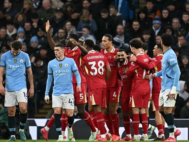 Pemain depan Liverpool, Mohamed Salah bersama rekan setimnya merayakan gol pembuka keunggulan atas Manchester City pada lanjutan Premier League 2024/2025 di Etihad Stadium, Manchester, Inggris, pada 23 Februari 2025. (Paul ELLIS/AFP)