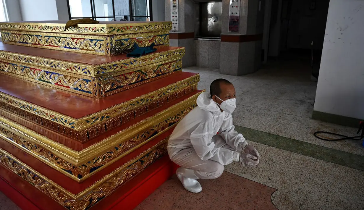 Seorang biksu beristirahat setelah melakukan kremasi untuk korban virus corona COVID-19 di Wat Chin Wararam Worawihan, Bangkok, Thailand, 30 Juli 2021. Kasus COVID-19 di Thailand kini tengah melonjak. (Lillian SUWANRUMPHA/AFP)