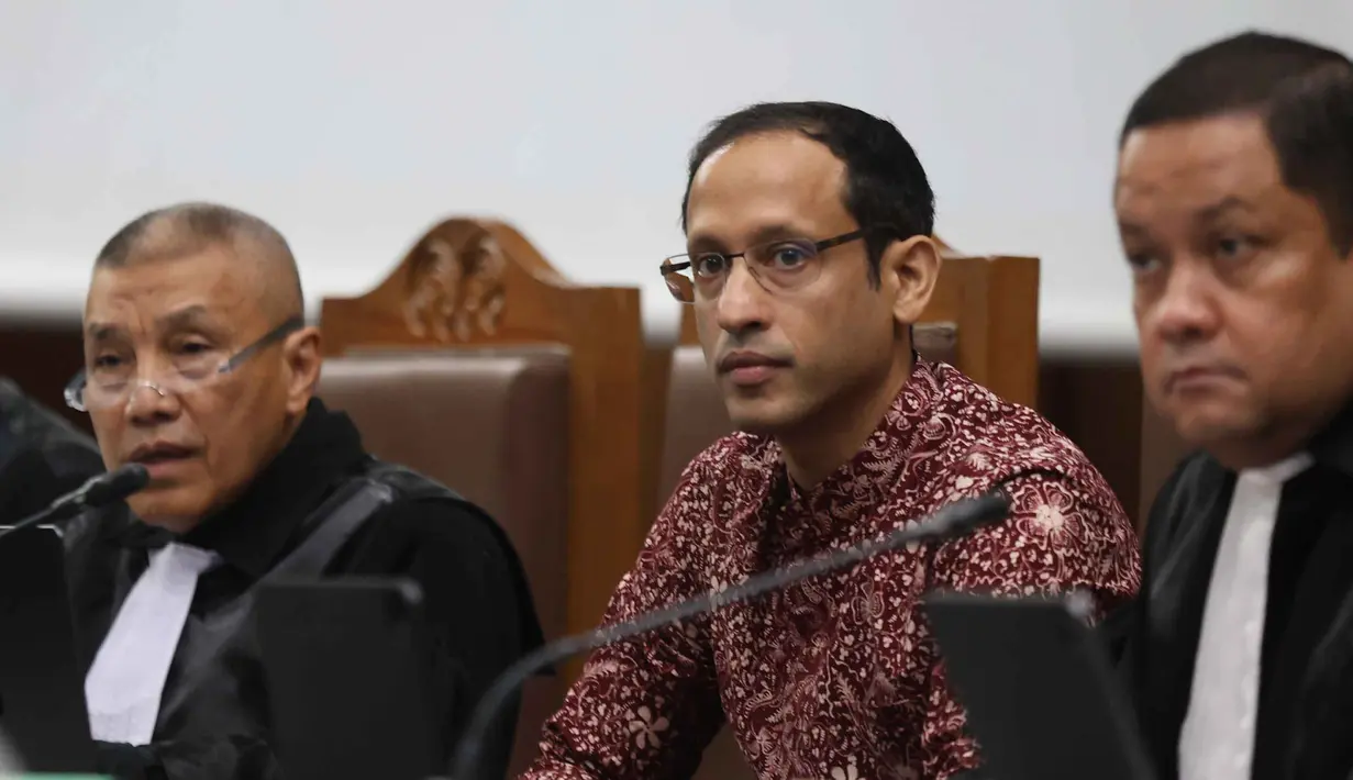 Nadiem Makarim juga menjelaskan bahwa tindakan medis tersebut baru akan dijalani dalam waktu dekat dan bersifat pengobatan rutin pasca-operasi. Tampak dalam foto, mantan Menteri Pendidikan, Kebudayaan, Riset dan Teknologi (Mendikbudristek), Nadiem Makarim (tengah) sesaat sebelum mengikuti persidangan lanjutan di Pengadilan Tindak Pidana Korupsi Jakarta (Tipikor) Jakarta, Senin (2/2/2026). (Kapanlagi.com/Budy Santoso)