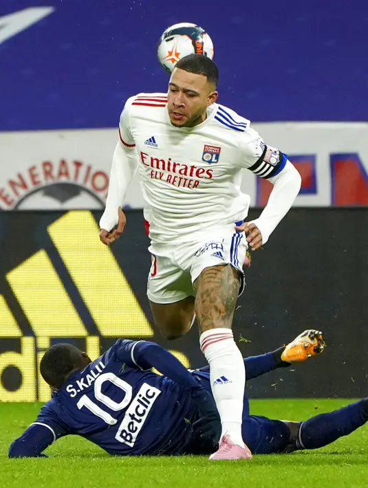 Pemain Lyon Memphis Depay (atas) ditakling pemain Bordeaux Samuel Kalu pada pertandingan Liga Prancis di Lyon, Prancis, Jumat (29/1/2021). Lyon menang 2-1 atas Bordeaux dan naik ke puncak klasemen sementara Liga Prancis menyalip Paris Saint-Germain (PSG). (AP Photo/Laurent Cipriani)