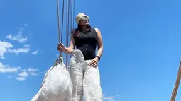 Berpose di ujung kapal mengandalkan latar langit biru tanpa noda, Fitri Salhuteru tampil simpel dengan celana panjang putih polos plus atasan hitam tanpa lengan. Penampilannya makin cetar dengan penutup kepala dan kacamata gelap. “Sailing day 1,” ujar Fitri Salhuteru sebagai status teks bersama pose yang menarik perhatian Donna Agnesia ini. (Foto: Instagram @fitri_salhuteru)