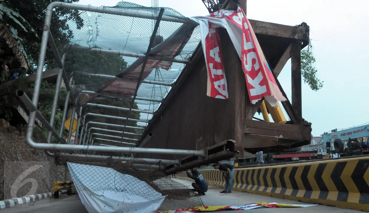 Petugas melihat Jembatan Penyeberangan Orang (JPO) yang roboh usai ditabrak truk trailer di KM 7.600 Tol BSD, Tangsel, Senin (16/5). Petugas Jasamarga mengevakuasi JPO menggunakan dua unit mobil crane. (Liputan6.com/Helmi Afandi)
