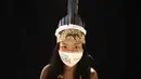 Vanda Ortega (33) dari kelompok etnis pribumi Witoto mengenakan pakaian tradisional sukunya dan masker saat pandemi virus corona COVID-19 di Taman Suku, Manaus, Brasil, Minggu (31/5/2020). Ortega telah menjadi salah satu simbol perjuangan masyarakat pribumi melawan pandemi. (AP Photo/Felipe Dana)