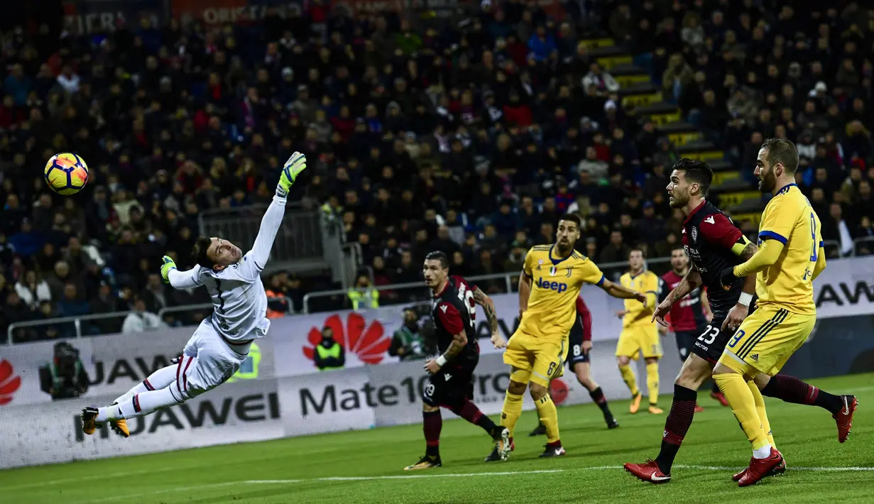 Kiper Cagliari, Rafael de Andrade, berusaha menepis bola tendangan pemain Juventus pada laga Serie A Italia di Stadion Sardegna, Cagliari, Sabtu (6/1/2018). Cagliari kalah 0-1 dari Juventus. (AFP/Miguel Medina)