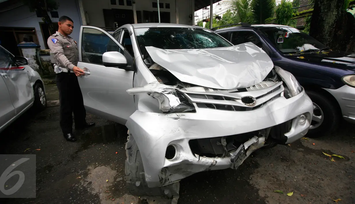 Petugas menunjukan mobil yang ringsek akibat kecelakaan lalulintas di simpang empat Tugu Pal Putih Yogyakarta, Senin (30/5).Korban tewas merupakan pasangan suami istri yang sedang menaiki motor. (Boy Harjanto)