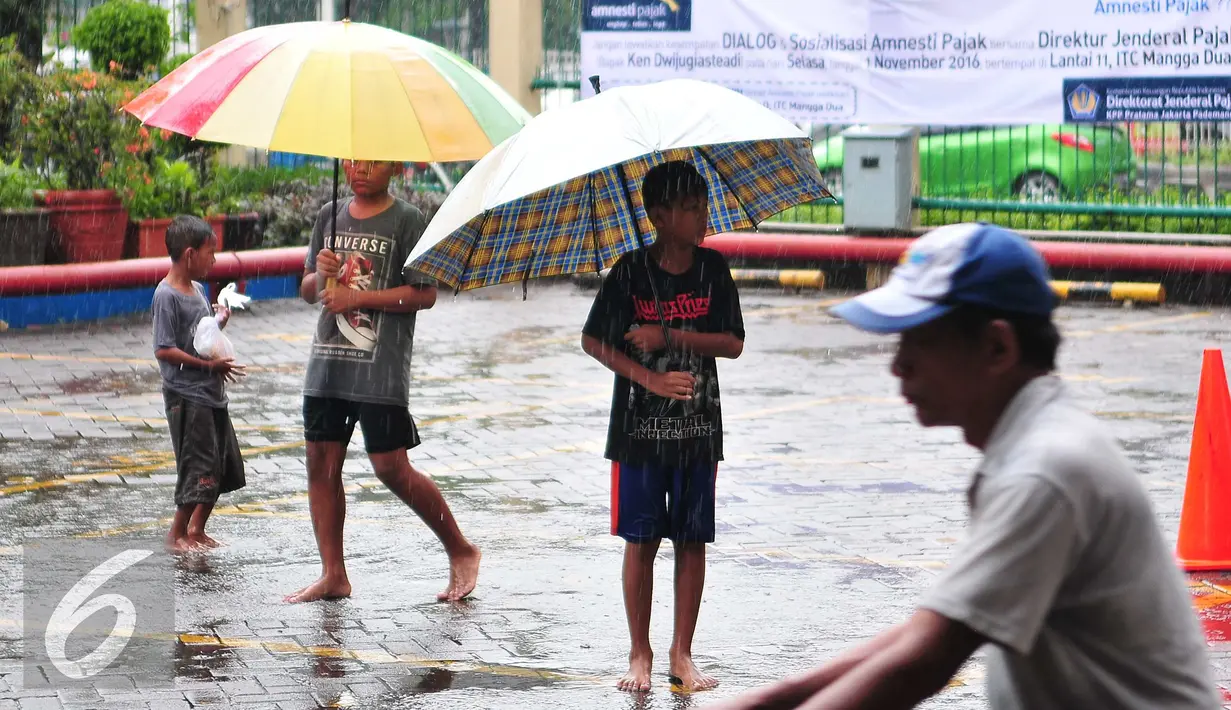 Bocah pengojek payung menunggu calon konsumen di tengah guyuran hujan, Jakarta, Selasa (1/11). Mereka mengenakan biaya jasa sewa payung mulai dari Rp.2000 hingga Rp.5000. (Liputan6.com/Angga Yuniar)