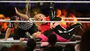 Pegulat Lacey Evans berusaha mengunci lawannya, Natalya Neidhart pada pertarungan World Wrestling Entertainment (WWE) untuk perempuan di Stadion Internasional King Fahd, Riyadh, 31 Oktober 2019. Kerajaan Arab Saudi untuk pertama kalinya menggelar pertandingan gulat WWE perempuan. (AP/Amr Nabil)