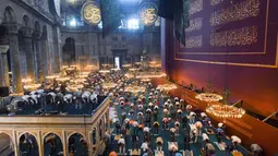 Jemaah mengenakan masker dan menerapkan jaga jarak untuk menghindari penularan COVID-19 saat melaksanakan salat Idul Adha di Hagia Sophia, Istanbul, Turki, Jumat (31/7/2020). Ini merupakan salat Idul Adha pertama di Hagia Sophia setelah dialihfungsikan dari museum menjadi masjid. (Pool via AP)