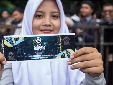 Seorang suporter menunjukan tiket yang baru dibelinya pada loket di Kompleks SUGBK, Jakarta Selatan, Jumat (2/12/2016). Timnas Indonesia akan menghadapi Vietnam pada semifinal Piala AFF 2016. (Bola.com/Vitalis Yogi Trisna)