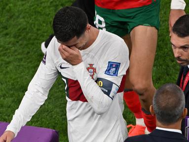 Timnas Maroko terus melanjutkan kejutannya di Piala Dunia 2022. Dalam babak perempatfinal, Sabtu (10/12/2022) malam WIB, Tim Singa Atlas mampu menyingkirkan Portugal lewat kemenangan tipis 1-0 untuk terus melaju dan menjadi negara Afrika pertama sepanjang sejarah yang mampu menembus babak semifinal Piala Dunia. Sementara itu, kekalahan Portugal membuat duka mendalam bagi Cristiano Ronaldo yang nyatanya kembali tak dipercaya menjadi starter dalam laga tersebut. (AFP/Nelson Almeida)