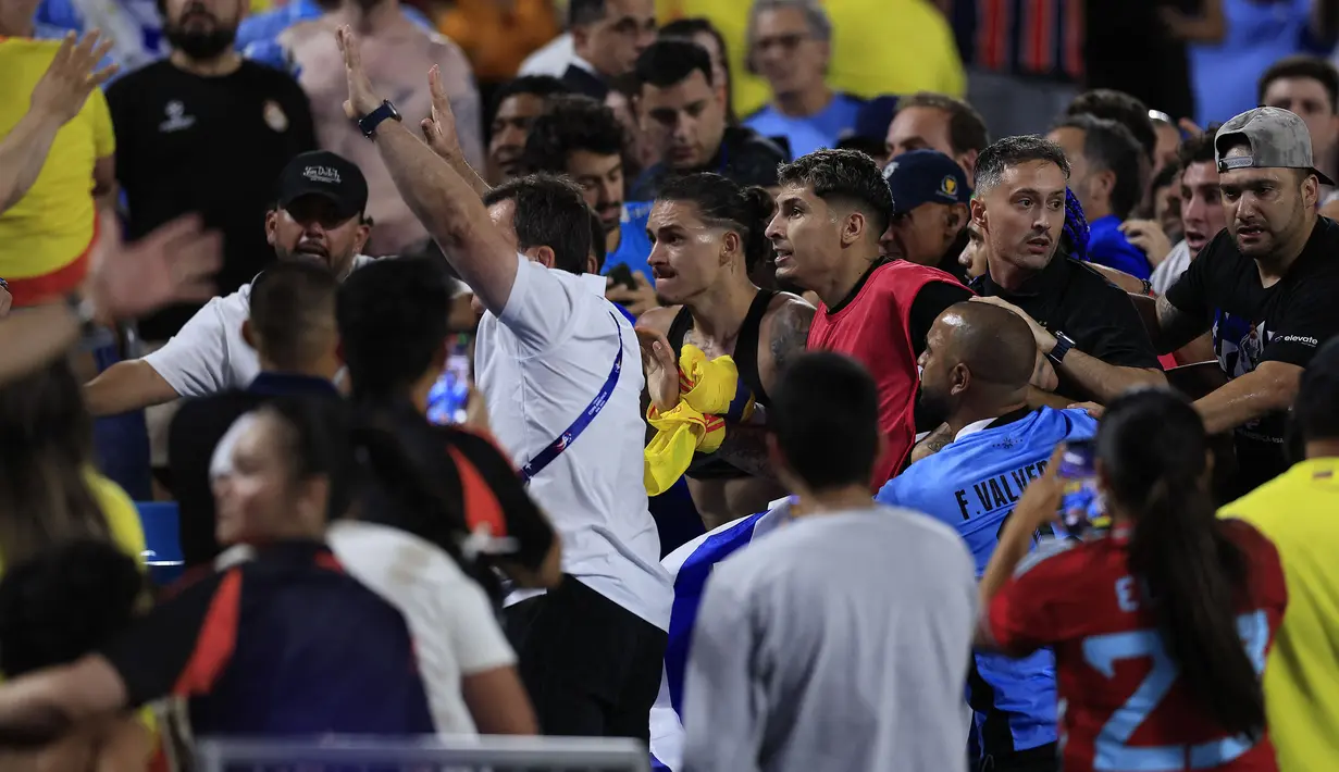 Striker Timnas Uruguay, Darwin Nunez (tengah) bersama rekan setim berusaha menghampiri suporter lawan di atas tribun penonton usai berakhirnya laga semifinal Copa America 2024 di Bank of America Stadium, Charlotte, Amerika Serikat, Kamis (11/7/2024) pagi WIB. (AFP/Getty Images/Buda Mendes)
