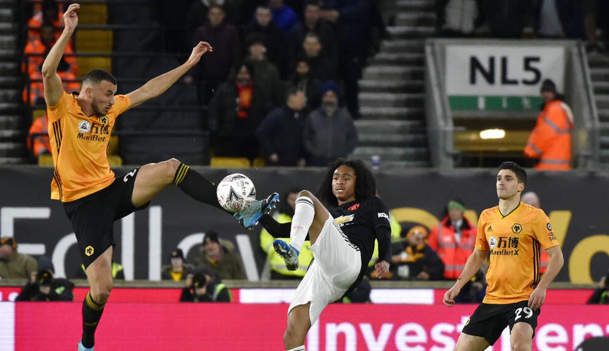 Pemain Manchester United, Tahith Chong, berebut bola dengan pemain Wolverhampton Wanderers, Romain Saiss, pada laga Piala FA di Stadion Molineux, Sabtu (4/1/2020). Kedua tim bermain imbang 0-0. (AP/Rui Vieira)