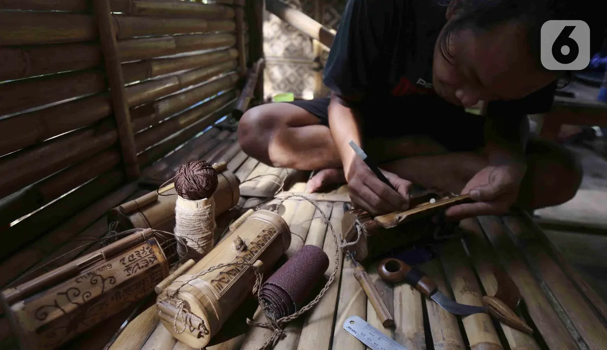 Perajin membuat kerajinan tas dari limbah bambu di Grand Depok City, Depok, Jawa Barat, Kamis (2/6/2022). Komunitas Ciliwung Depok (KCD) memanfaatkan limbah bambu yang berada di Sungai Ciliwung menjadi kerajinan seperti tas, tempat alat tulis, dan cangkir. (Liputan6.com/Herman Zakharia)
