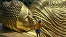 Ritual memandikan patung Buddha Maha Paranibbana atau yang biasa disebut patung Buddha tidur merupakan tradisi di Maha Vihara Mojopahit, Mojokerto. (JUNI KRISWANTO/AFP)