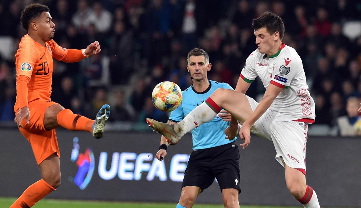 Striker Belanda, Donyell Malen, berebut bola dengan gelandang Belarusia, Stanislav Dragun, pada laga Kualifikasi Piala Eropa 2020 di Minsk, Minggu (13/10). Belarusia kalah 1-2 dari Belanda. (AFP/Sergei Gapon)