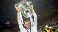 Bintang Real Madrid, Gareth Bale, saat mengangkat trofi Liga Champions 2015-16, usai mengalahkan Atletico Madrid 5-3 lewat babak adu penalti, di San Siro, Milan, Sabtu (28/5/2016). (AFP/Filippo Monteforte). 