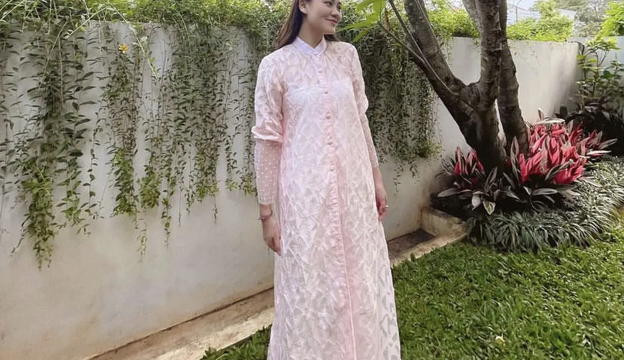 Ia juga tampil dibalut dress panjang berkancing warna pink. Ia tampil manis mengenakan bondu warna serasi. [@aaliyah.massaid]
