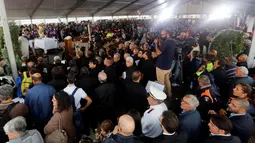 Seluruh keluarga dan kerabat berkumpul di area pemakaman korban gempa bumi yang meratakan kota di Amatrice, Italia tengah, Selasa (30/8). Hampir 300 orang tewas saat gempa bumi 6,2 SR melanda Amatrice dan sekitarnya 24 Agustus lalu. (REUTERS/Ciro De Luca)