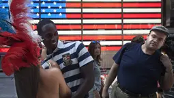 Seorang wanita berpose bersama seorang wisatawan dipinggiran ruas jalan Times Square, New York,AS,  Selasa (18/8/2015). Mereka meminta uang kepada para wisatawan yang ingin mengajak foto bersama dengan tanpa memakai busana. (REUTERS/Carlo Allegri)