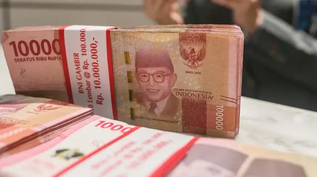 Teller menunjukan mata uang rupiah di Jakarta, Senin (26/2/2024). (Liputan6.com/Angga Yuniar)