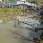 Para peserta pria berkonsentrasi dengan kailnya pada kompetisi memancing di sebuah kolam dekat desa Weilei di Negara Bagian Meghalaya, timur laut India, Sabtu (21/9/2019). Ratusan peserta berpartisipasi dalam kompetisi yang memperebutkan sejumlah hadia tersebut. (DIPTENDU DUTTA / AFP)